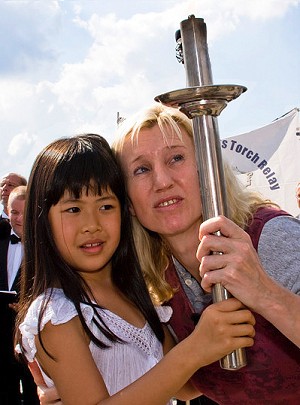 Former Olympian Ines Geipel carries the human rights torch with 7-year-old Australian Fadu Chen.