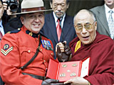 The Dalai Lama receives a gift from Royal Canadian Mounted Police Corporal Yvon Brault and Sgt. Monique Beauchamp upon his arrival on Parliament Hill, in Ottawa Monday Oct 29, 2007.