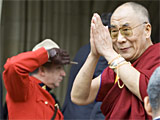 The Dalai Lama acknowledges followers as an RCMP officer salutes upon his arrival on Parliament Hill in Ottawa, Monday, Oct 29, 2007.