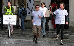 Runners Ondrej Liska, MP and Martin Bursik, Minister of Environment, bring the torch to Prague 's Old Town Square.