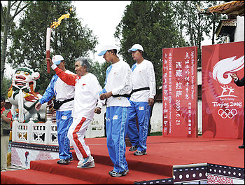 An Olympic torchbearer sets out on a relay through the streets of Lhasa, capital of southwest China's Tibet Autonomous Region on Saturday, June 21, 2008. The Olympic torch made its way through Tibet's sealed-off capital Saturday.
